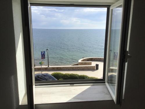 ein Fenster mit Meerblick von einem Gebäude in der Unterkunft Apartments Tomato in Novigrad Istria