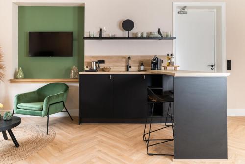 a kitchen with a sink and a green chair at Bed en Baguette in Burgh Haamstede