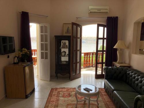 een woonkamer met een bank en een tafel bij Nile Castle in Luxor