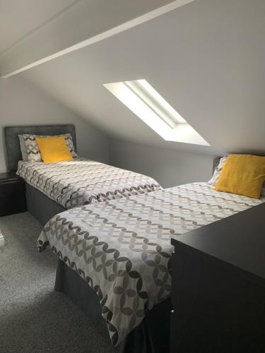 a bedroom with two beds and a skylight at Armada Guesthouse in Redcar