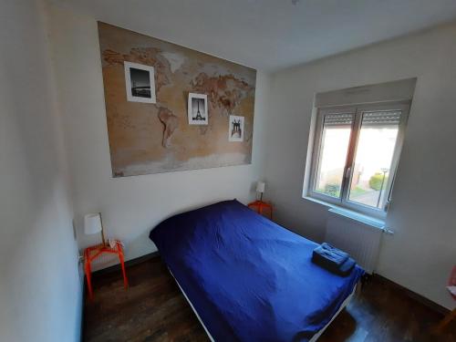 een slaapkamer met een blauw bed en een raam bij Hyper centre, Wifi, proche gare in Valenciennes