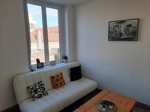 een woonkamer met een witte bank en een raam bij Hyper centre, Wifi, proche gare in Valenciennes