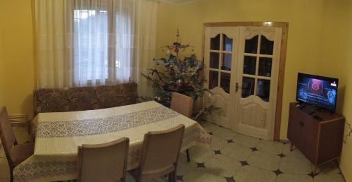 a dining room with a table and a tv in it at Гірська роса in Verkhniy Yasenov