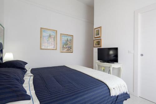 a white bedroom with a bed and a tv at Come Eravamo in Monterosso al Mare
