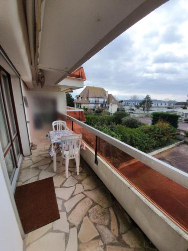 d'un balcon avec une table et une vue sur la rue. dans l'établissement Apt At 2 Steps From The Beach And Proust Promenade, à Cabourg