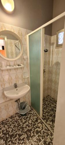 łazienka z umywalką i prysznicem z lustrem w obiekcie Hotel Astoria w mieście Riccione