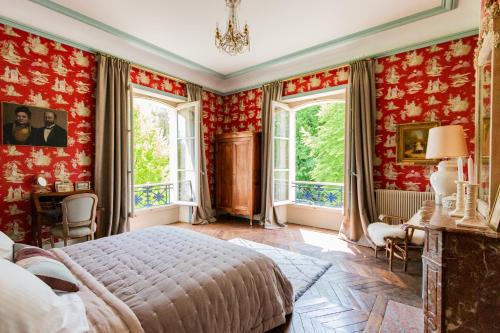 a bedroom with red walls and a bed and windows at Château de Cesny-aux-Vignes in Cesny-aux-Vignes