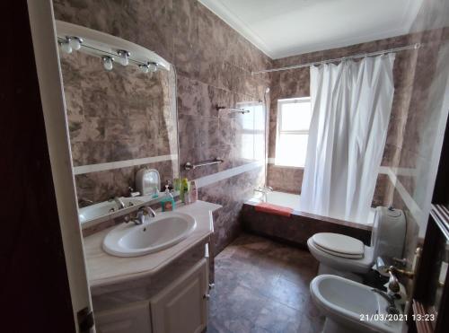 un bagno con lavandino, WC e specchio di Villa Ramos ad Albufeira
