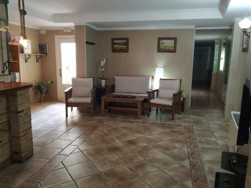 a living room with two chairs and a table at Hostal Los Escudos in Almagro