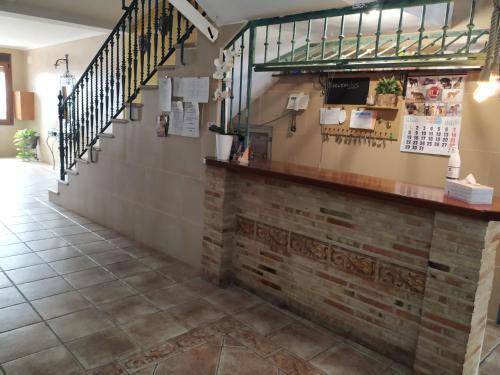 a lobby with a brick wall and stairs at Hostal Los Escudos in Almagro