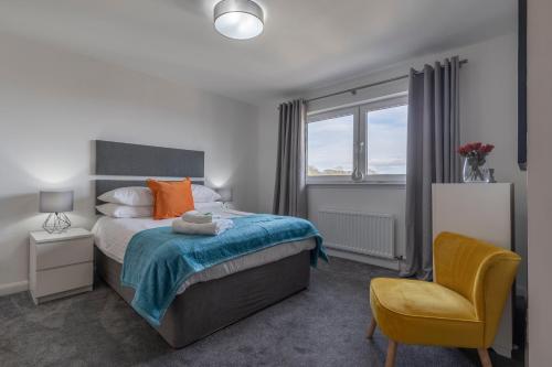a bedroom with a bed and a chair and a window at Parkhill Luxury Serviced Apartments - Hilton Campus in Aberdeen
