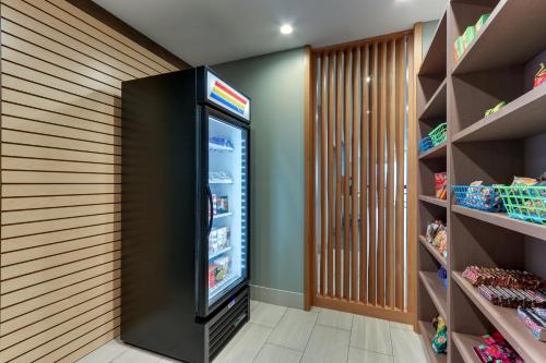 a large black refrigerator in a room with shelves at Holiday Inn Express & Suites - Saugerties - Hudson Valley by IHG in Saugerties