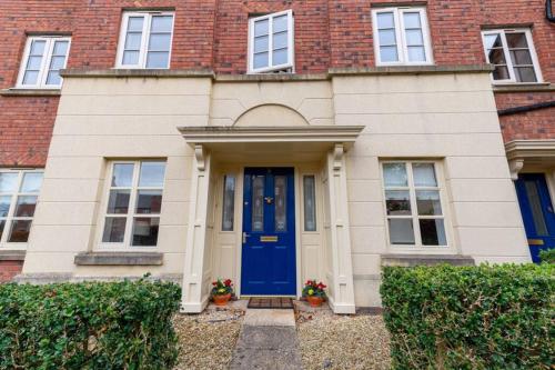 uma casa de tijolos com uma porta azul e janelas em Burlington Place, Shrewsbury. 2 bedroom, private parking, 5 minutes from town em Shrewsbury