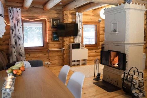 a dining room with a fireplace in a log cabin at The lake house with a beautifull view in Vikipalu