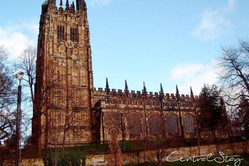 a large building with a tower with a clock on it at Wrexham Central Stay Apartment Seven in Wrexham