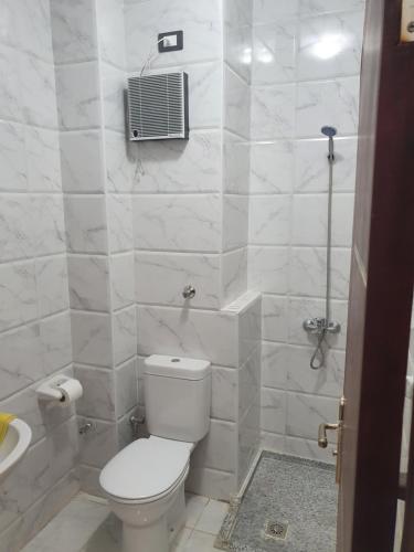 a white bathroom with a toilet and a shower at Tiba View in Hurghada