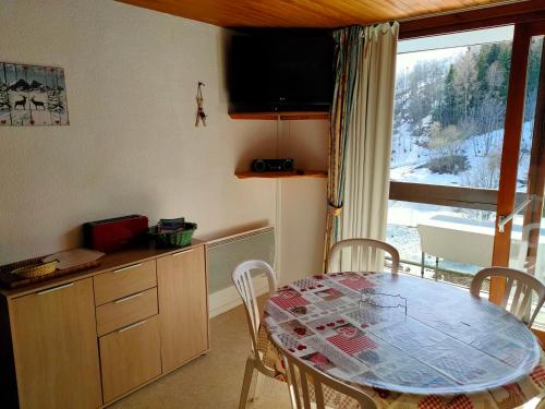 a kitchen with a table with chairs and a window at Corbier centre Vostok 32m2 balcon Sud vue pistes Classé Tourisme in Le Corbier