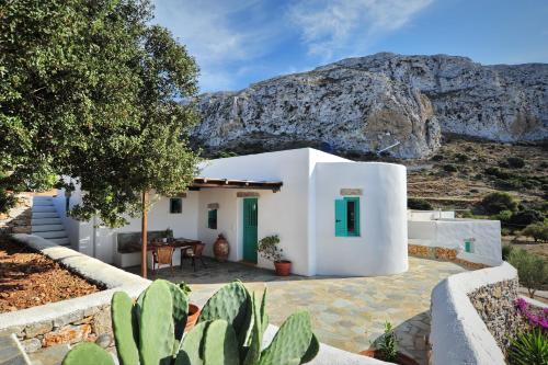 a white house with a mountain in the background at Alonistria in Órmos Aiyialís