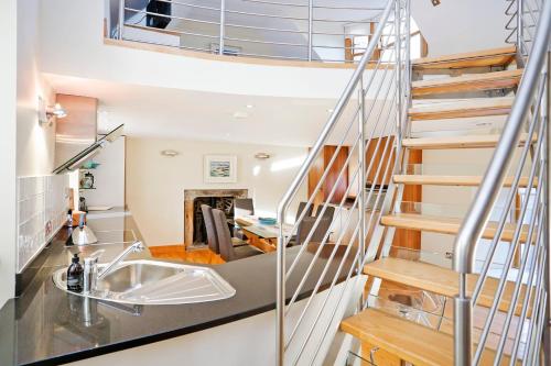 a staircase in a house with a sink and a living room at ALTIDO Unique Mezzanine Apartment in St Andrews in St Andrews