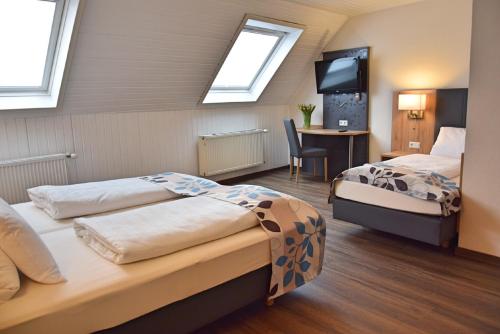 a hotel room with two beds and a television at Cafe-Hotel Altreuter in Nördlingen