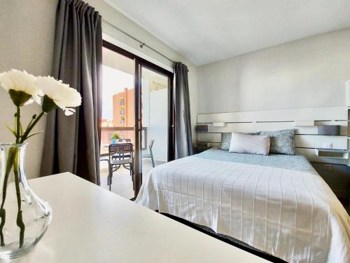 a bedroom with a bed and a vase with flowers on a table at Apartamento Lucilú in Puerto de la Cruz