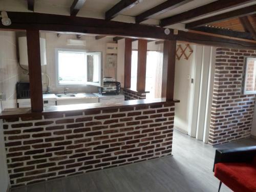 - une cuisine avec un mur en briques et un évier dans l'établissement La Petite maison en Sologne, à Salbris