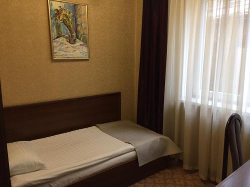 a small bed in a room with a window at Hotel-Restaurant Lyube Plus in Khmelnytskyi