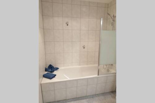 a white bath tub in a white tiled bathroom at Quartier am Markt- Ferienwohnung in Bad Gottleuba