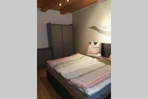 um pequeno quarto com uma cama num quarto em Quartier am Markt- Ferienwohnung em Bad Gottleuba