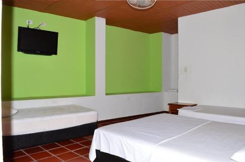 a room with two beds and a flat screen tv at Meson Hondano in Honda