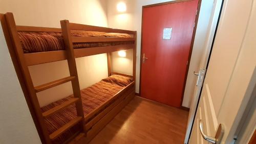 Camera con 2 letti a castello e una porta rossa di Appartement résidence des Bottières a Saint-Pancrace
