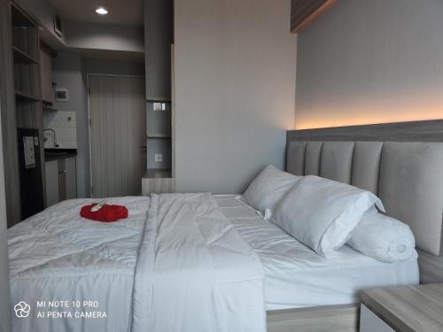 - un grand lit blanc avec un article rouge dans l'établissement Studio standard A by DA Room, à Pekayon Satu
