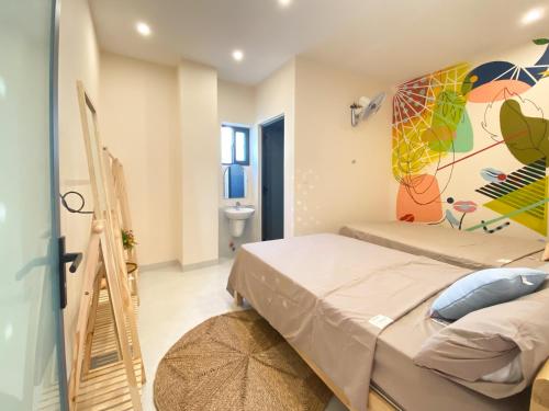 a bedroom with a bed and a painting on the wall at Dear House near Bai Sau beach in Vung Tau