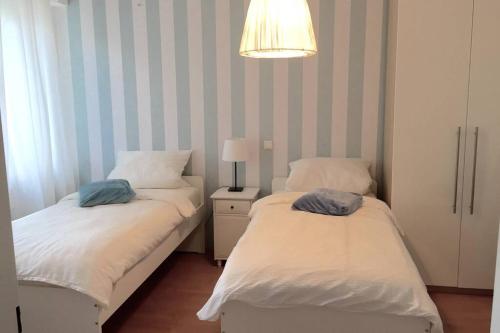 - 2 lits dans une petite chambre avec une lampe dans l'établissement Apartment 120 qm -3 Schlafzimmer-2 Bäder- für 8 Gäste, à Düsseldorf