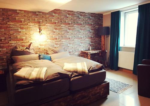 a bed in a room with a brick wall at Hotel Geismarburg in Göttingen