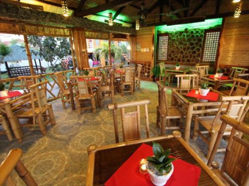 an empty restaurant with wooden tables and chairs at P&M Final Option Beach Resort in San Juan