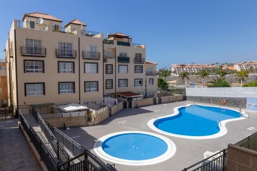a building with a large swimming pool next to a building at Aqua Vista 2 bed Penthouse with great views in Callao Salvaje