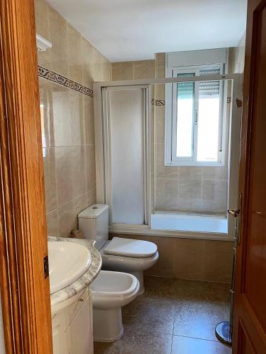 a bathroom with a toilet and a sink and a tub at El Castell Orange Costa in Alcossebre