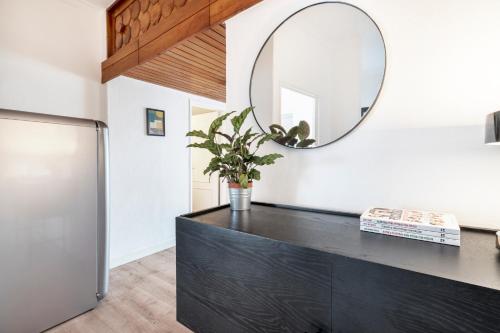 een spiegel bovenop een zwarte dressoir in een kamer bij Comfy Apartment by Olala Homes in Cascais
