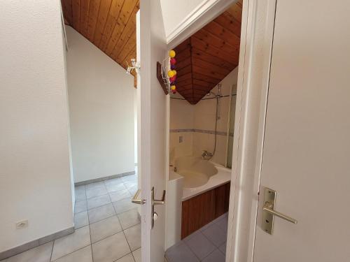 La salle de bains est pourvue d'une baignoire et d'un lavabo. dans l'établissement Agréable T3 mezzanine jusqu'à 5 personnes, à Briançon
