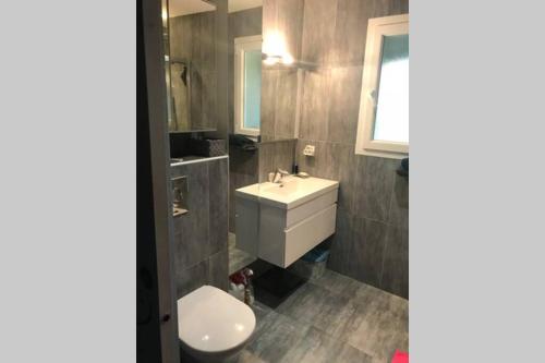 a bathroom with a white sink and a toilet at Villa luxe bord de mer avec piscine et grand jardin in Corbara