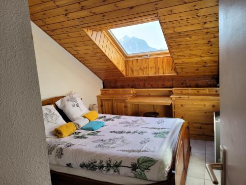 - une chambre avec un lit dans une pièce dotée d'une fenêtre dans l'établissement Agréable T3 mezzanine jusqu'à 5 personnes, à Briançon