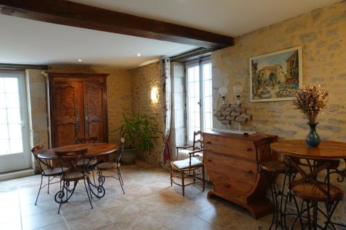 Zimmer mit 2 Tischen, Stühlen und Fenstern in der Unterkunft Gîte 4 étoiles avec hébergement insolite - 10 personnes in Foussais