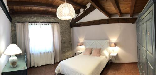 um quarto com uma cama branca e uma janela em La Fábrica de Boldó em Cinctorres