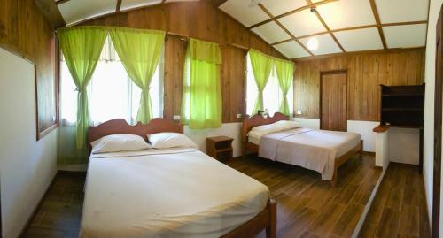 a bedroom with two beds and a television in it at Casa Mairena in Caño Negro