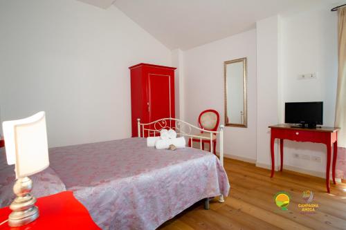 a bedroom with a bed with a red cabinet and a desk at Agriturismo Colombera in Quarto dʼAltino