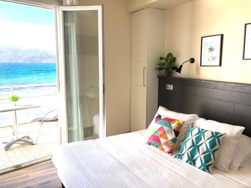 a bedroom with a bed with a view of the ocean at Le Cannier Hotel in La Seyne-sur-Mer