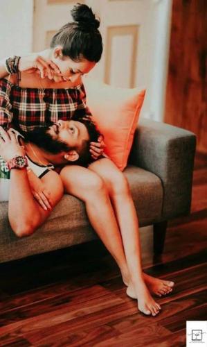 a woman standing on top of a man sitting on a couch at Eden Studio Apartments - 1 in Colombo