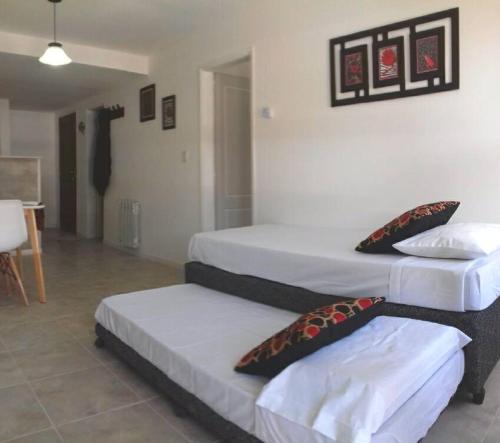 a room with three beds with pillows on them at Reina Mora Apart Bariloche in San Carlos de Bariloche