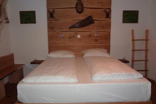 a large bed in a bedroom with a wooden headboard at Charmante rustikale Jägersuite mit el Kamin H2O Therme Oberhof in Oberhof